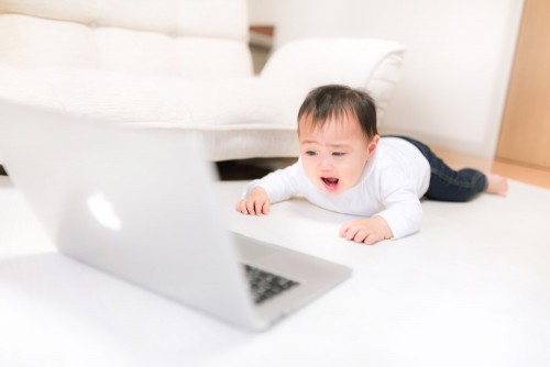 ノートパソコンをみて喜ぶ赤ちゃん